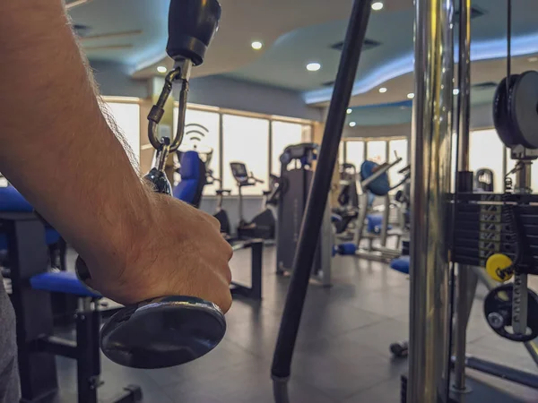 Κλείσιμο των χεριών του ανθρώπου τραβώντας το βάρος σε ένα σύγχρονο εσωτερικό γυμναστήριο για την οικοδόμηση του σώματος και αυξάνοντας τη δύναμη και την απώλεια βάρους — Φωτογραφία Αρχείου