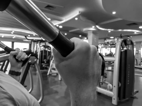 Κλείσιμο των χεριών του ανθρώπου, ενώ άρση βάρους σε ένα γυμναστήριο και να κάνει το bodybuilding και την αύξηση της δύναμης σε μαύρο και άσπρο — Φωτογραφία Αρχείου