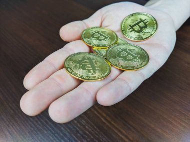 Avuçlarında altın bitsikkeler tutarak kripto para biriminin büyümesini ve ekonomik küresel değişim ile yatırımlardaki başarıyı temsil ediyorlar.