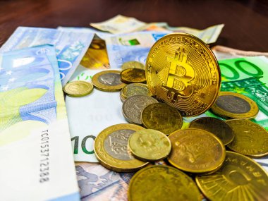 Altın Bitcoin madeni para ve çeşitli para birimlerinin üzerine serili diğer metal madeni paralar farklı seçenekler ve küresel uluslararası ticaret seçenekleri olarak kağıt para