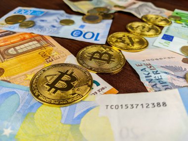 Altın bitsikkeler kağıt para banknotları arasında mükemmel bir şekilde dizilmiş çeşitli dünya para birimlerinin farklı seçenekler konseptini temsil eden rastgele yayılmış