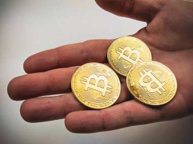 İnternetten dijital çağ için yeni piyasa değeri olan fiziksel ürünler almak için avuç içinde altın bitcoin paralar göstermek.