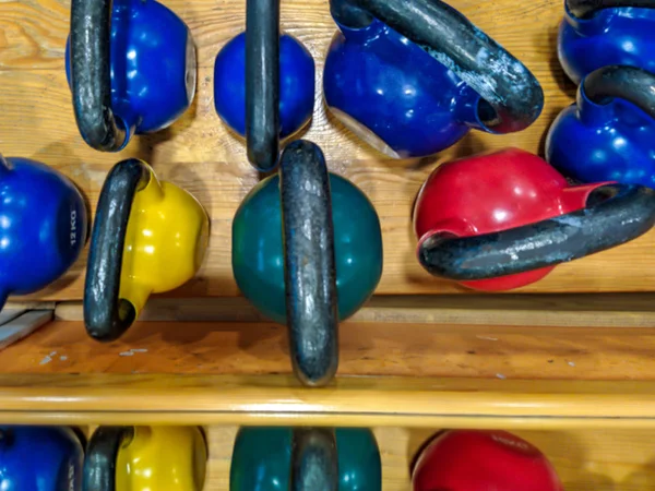 Top view of kettlebell dumbbells in different colors and weights stacked as part of modern gym equipment ready to be used for bodybuilding and weightlifting — 스톡 사진