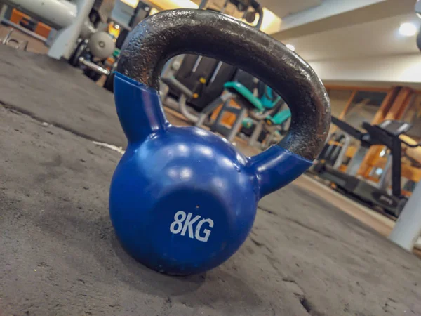 Kettlebell comme haltère rond en forme de boule de 8 kilogrammes placé sur l'intérieur du sol de la salle de gym pour la perte de poids et la musculation pour un mode de vie sain — Photo