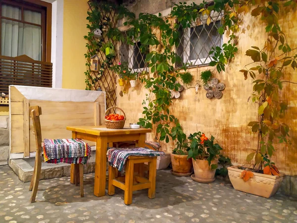 Çiçekler, eski tarz döşemeler ve duvarlar gibi doğal dekorasyonu olan küçük ahşap masa ve sandalyeden oluşan güzel bir retro set.