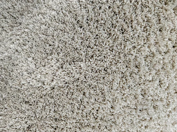 Miękki i ciepły puszysty dywan w kolorze beżowym, wykonany z naturalnej wełny, stosowany w aranżacji wnętrz — Zdjęcie stockowe
