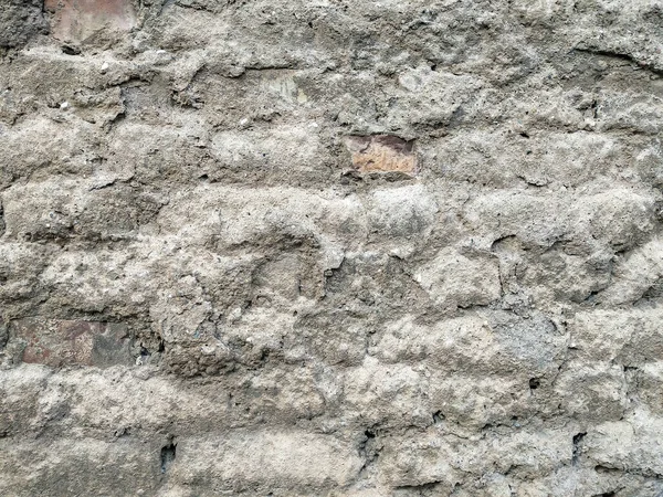Стара виглядає стіна з грубим дотиком до текстури і цегли, що показує під старим будинком, готовим до ремонту — стокове фото