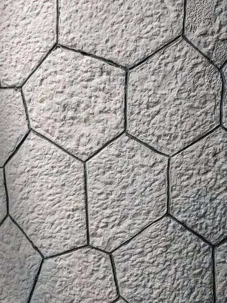 Padrão interessante de tijolos brancos em forma hexagonal na parede ou no chão, feitos de pedra de rocha com estilo contemporâneo de azulejos irregulares — Fotografia de Stock