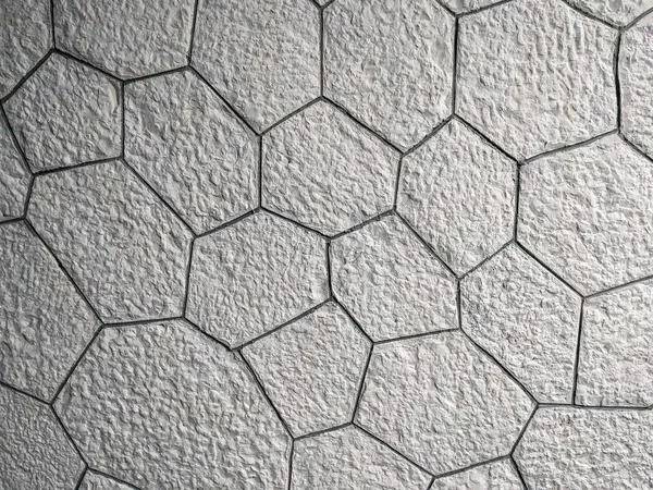 Modèle intéressant de briques blanches en forme hexagonale sur le mur ou le sol, en pierre de roche et un fond d'écran moderne — Photo