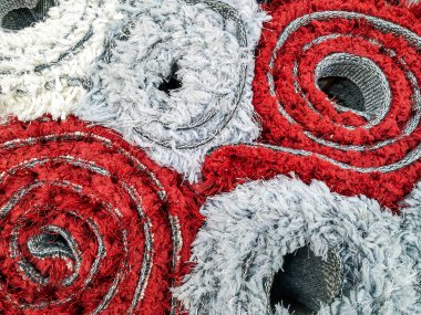 Beyaz, kırmızı, sıcak ve yumuşak halılar, mağazada satılığa çıkarılmış yeni halılar gibi birbirlerinin üzerine yığıldılar. Ev dekorasyonu için.