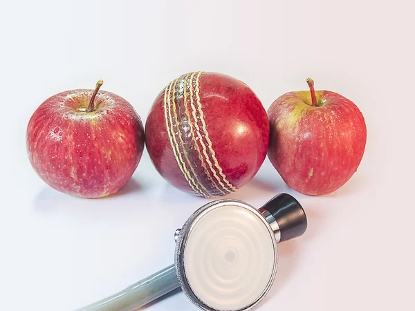 Two Apples a Stethoscope and a Duece ball.Health for sports .