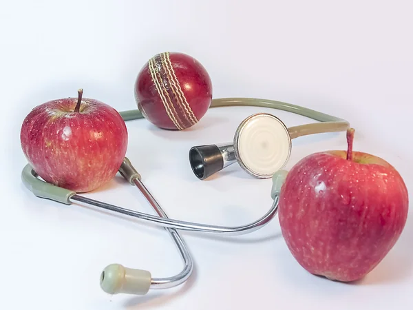 Two Apples a Stethoscope and a Duece ball.Health for sports .