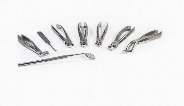 Tandheelkundige instrumenten gerangschikt op witte tafel. — Stockfoto