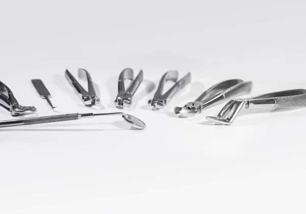 Tandheelkundige instrumenten gerangschikt op witte tafel. — Stockfoto