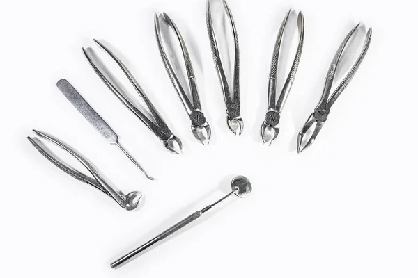 Dentální nástroje, které jsou uspořádány na bílém stole. — Stock fotografie