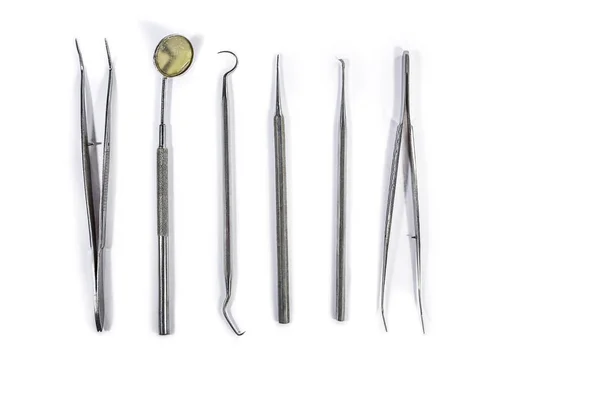 Dentální nástroje, které jsou uspořádány na bílém stole. Stock Fotografie