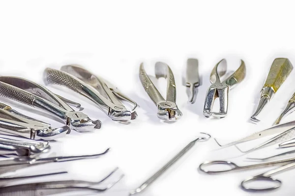 Dental Instruments some arranged and some not arranged on white table arranged in some pattern. — Stock Photo, Image