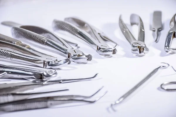 Tandheelkundige instrumenten sommige gerangschikt en sommige niet gerangschikt op witte tafel in sommige patroon zijn gerangschikt. — Stockfoto