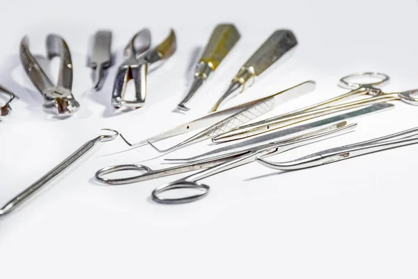 Instrumentos Dentários alguns arranjados e outros não dispostos em mesa branca dispostos em algum padrão . — Fotografia de Stock