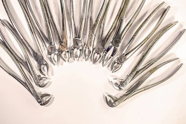 Dental Instruments some arranged and some not arranged on white table arranged in some pattern. — Stock Photo, Image