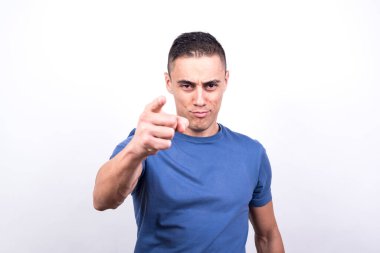 İşaret parmağıyla ön tarafı gösteren adam. Beyaz arkaplan, orta çekim