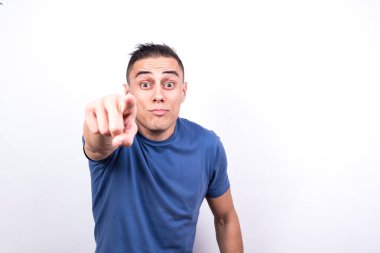 İşaret parmağıyla ön tarafı gösteren adam. Beyaz arkaplan, orta çekim