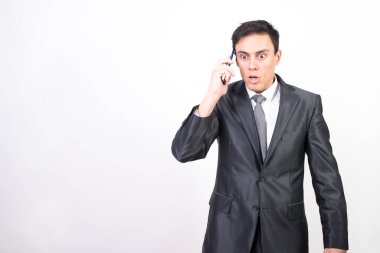Takım elbiseli adam telefonda sinirli sinirli konuşuyor. Beyaz arkaplan, orta çekim