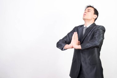 Takım elbiseli adam meditasyon yapıyor, beyaz arka plan, orta çekim.