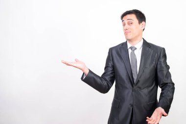 Takım elbiseli gülen adam fotokopi alanını işaret ediyor. Beyaz arkaplan, orta çekim