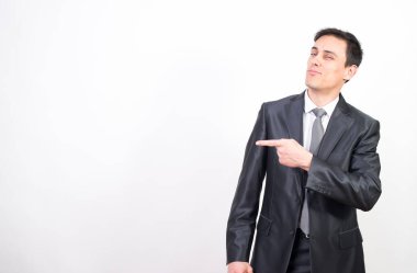 Takım elbiseli gülen adam fotokopi alanını işaret ediyor. Beyaz arkaplan, orta çekim