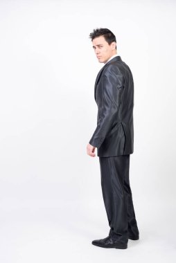 Takım elbiseli baştan çıkarıcı bir adam. Beyaz arkaplan, tüm vücut