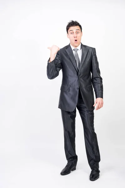 Takım elbiseli adamın kopya uzayı göstermesine şaşırdım. Beyaz arkaplan, tüm vücut