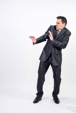 Beyaz arka planda takım elbiseli iğrenç bir adam geri çekiliyor. Tüm vücut