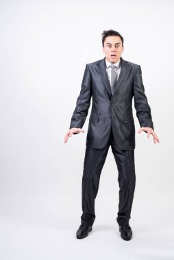 Beyaz arka planda takım elbiseli korkmuş bir adam.