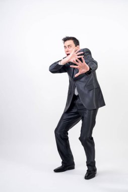 Beyaz arka planda takım elbiseli korkmuş bir adam.