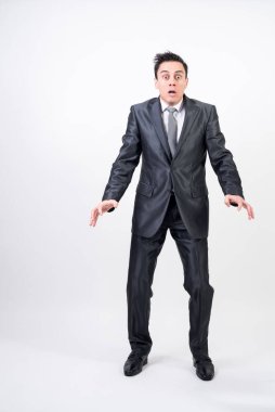 Beyaz arka planda takım elbiseli korkmuş bir adam.