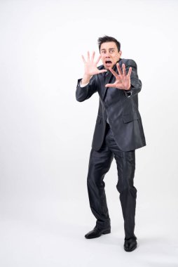 Beyaz arka planda takım elbiseli korkmuş bir adam.