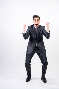 Takım elbiseli öforik adam bir şeyi kutluyor. Beyaz arka plan. Tüm vücut