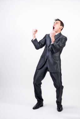 Takım elbiseli öforik adam bir şeyi kutluyor. Beyaz arka plan. Tüm vücut