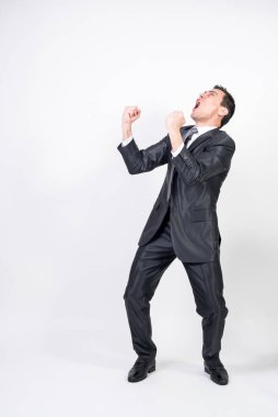 Takım elbiseli öforik adam bir şeyi kutluyor. Beyaz arka plan. Tüm vücut