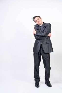 Takım elbiseli adam kendine sarılıyor. beyaz arkaplan, tüm vücut