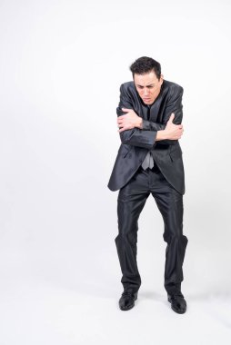 Takım elbiseli adam kollarıyla vücudunu donduruyor. beyaz arkaplan, tüm vücut