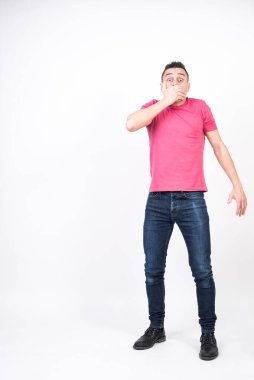 Adam elleriyle ağzını kapatıyor çünkü istemeden bir şey söylüyor. beyaz arkaplan, tüm vücut