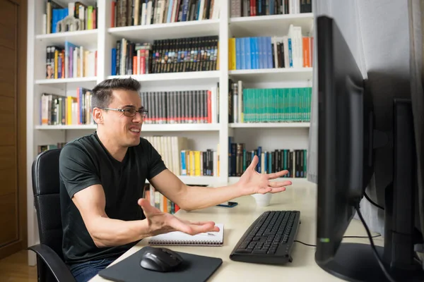 Bir şey anlamadığı için endişe ve umutsuzluk gösteren bir adam bilgisayarın önünde oturuyor. Orta çekim.