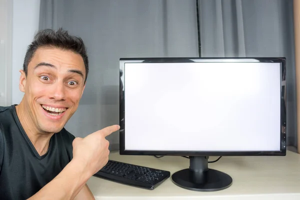 Smiling man in black shirt pointing at a computer screen (space copy) announcing important news. Close up.