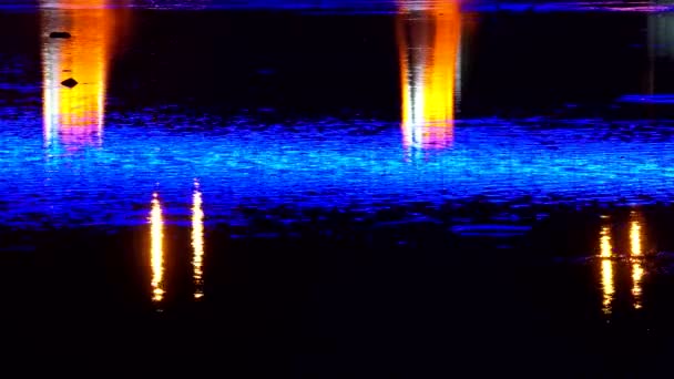 Fel licht in de nacht stad brug weerspiegeld in de verlichting A schilderachtige uitzicht op de rivier van een stadsgezicht bij nacht met lichten overal in de stad. Uzgorod — Stockvideo
