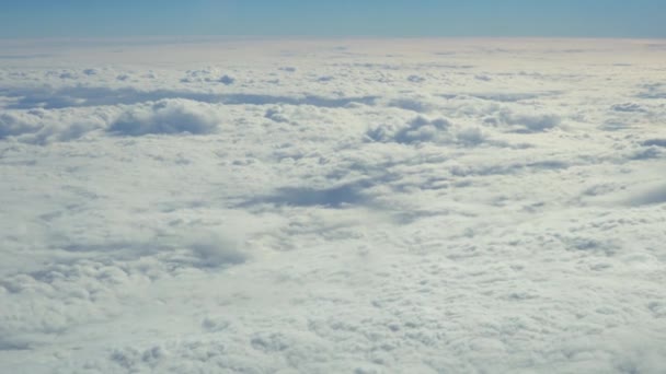 Blauwe hemel en witte heap wolken kijken door de patrijspoort van vliegende vliegtuig. — Stockvideo