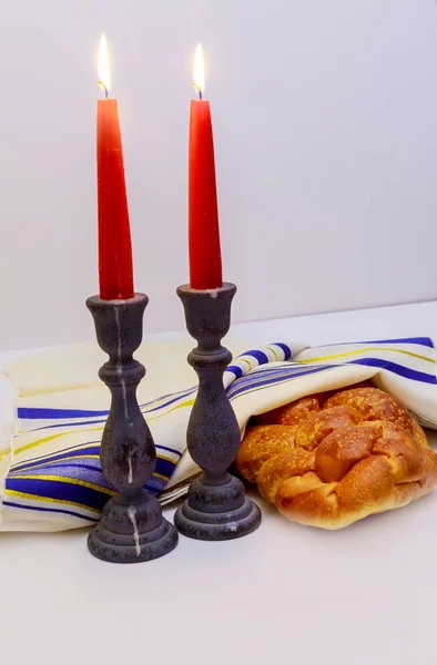 Tischdekoration für Shabbat mit brennenden Kerzen, Challahbrot und Wein. — Stockfoto