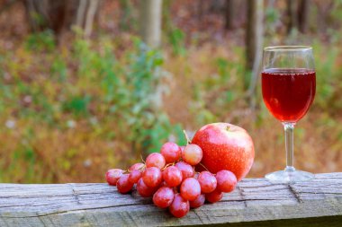 Kırmızı şarap cam ve ahşap masa üzerinde üzüm salkımı