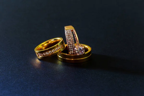 Złote obrączki ślubne z diamentami na białym tle czarne tło — Zdjęcie stockowe